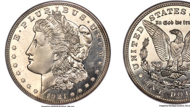 The 1921 Morgan dollar design, by George T. Morgan, features the laureate head facing left with the date below, flanked by stars.  On the reverse is the eagle within a half wreath.
