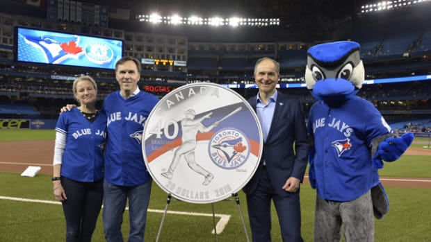 From left:  Royal Canadian Mint CEO Sandra Hanington, Minister of Finance Bill Morneau and Robert Witchel, Executive Director of Jays Care Foundation on April 22 unveil a new silver collector coin at Rogers Centre to celebrate the 40th season of the Toronto Blue Jays.
