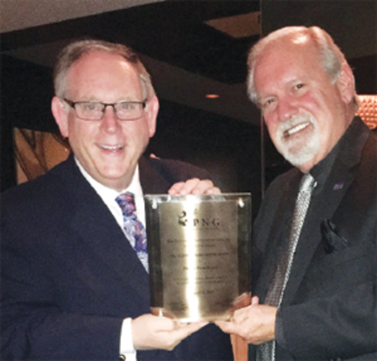  Donn Pearlman, left, receives the Lifetime Achievement Award plaque from Bob Brueggeman, PNG executive director.