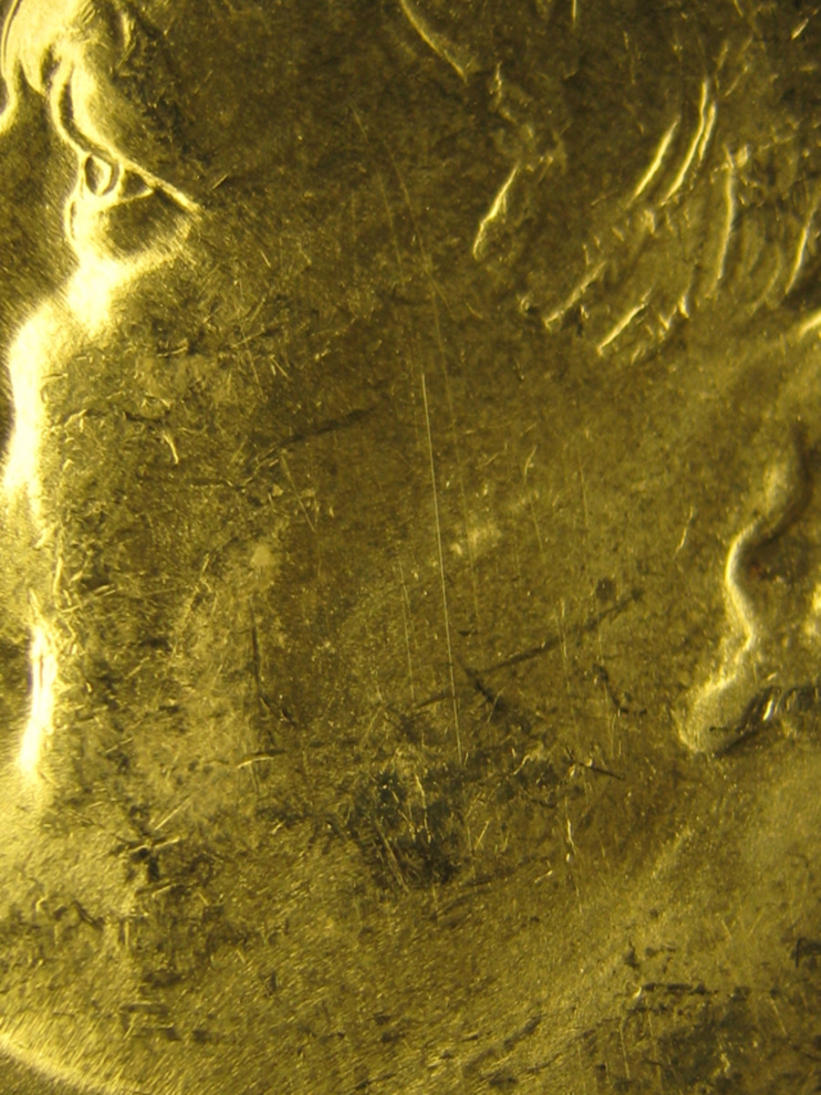 Figure 1 shows a mark on the cheek of a Kennedy half dollar that may be considered at the borderline between a hairline and a scratch.