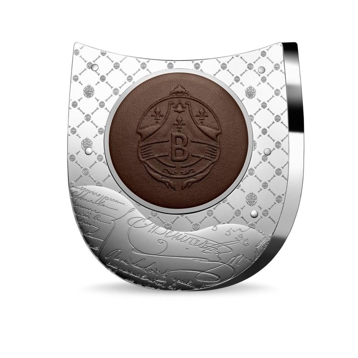 The reverse of the 500 Euro silver kilo Berluti coin features a patinated leather circle with the company emblem. The leather piece is crimped and embossed during the striking of the coin.