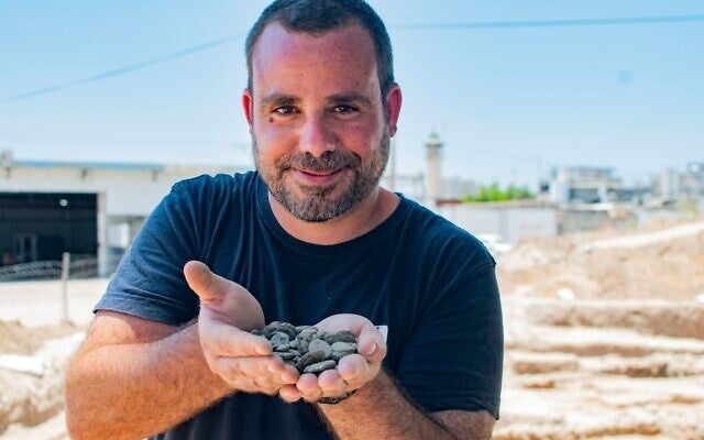 archaeologist-shahar-krispin-holds-some-of-the-cached-coins.jpg